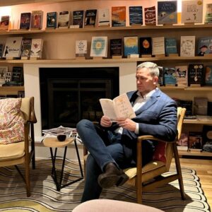 1700485226038 Author, Brandon Jenkins, reading a book in a study setting.