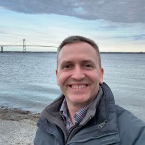 1712231702066 Author, Brandon Jenkins, standing in front of a bay with a bridge in the background. Accountability partner.