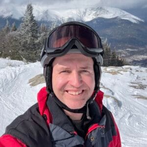 Coach Brandon Jenkins pictured on top of a mountain, in skiing attire. He writes about it being lonely at the top, and offers advice.