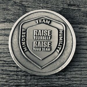 Image shows a challenge coin. Coach Brandon Jenkins writes about coaching unlocks potential.