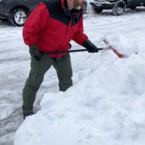 Coach Brandon Jenkins is pictured shoveling snow.