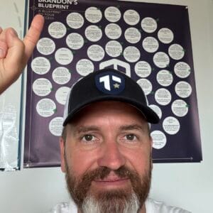 Coach Brandon Jenkins writes about choosing between two roles. He is pictured in his office, pointing at his Blueprint.