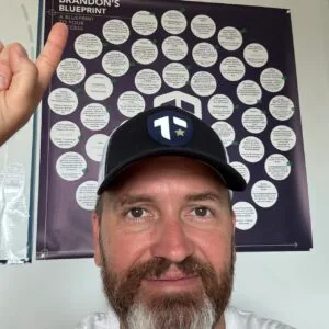Coach Brandon Jenkins writes about choosing between two roles. He is pictured in his office, pointing at his Blueprint.