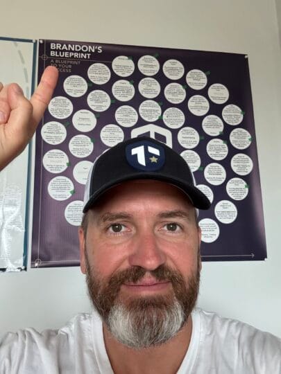 Coach Brandon Jenkins writes about choosing between two roles. He is pictured in his office, pointing at his Blueprint.