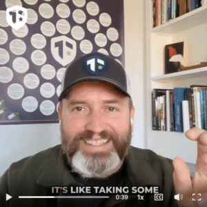Coach Brandon Jenkins speaks about leaders, time, and how to lead with more clarity. He is pictured in his offie, wearing a Tier One hat, seated in front of his blueprint and a bookshelf.
