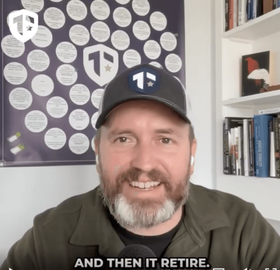 Coach Brandon Jenkins speaks and writes about the fog of transition. He is pictured in his office, wearing a green shirt and a Tier One hat.