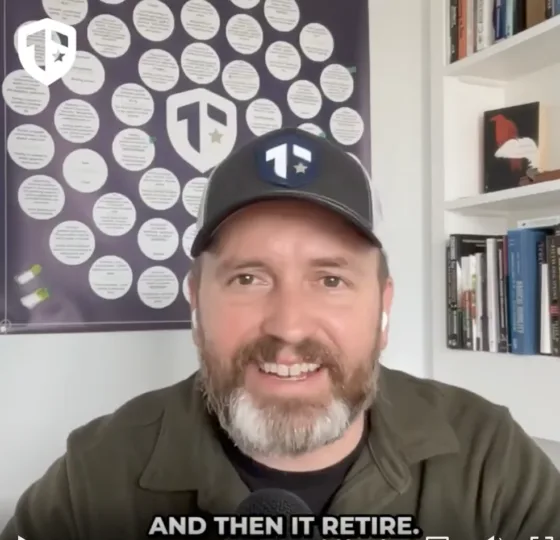 Coach Brandon Jenkins speaks and writes about the fog of transition. He is pictured in his office, wearing a green shirt and a Tier One hat.
