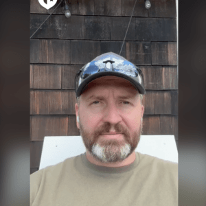 Coach Brandon Jenkins writes about the old arena. He is pictured outside, wearing a hat.