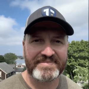 Coach Brandon Jenkins is pictured outside, wearing a Tier One hat.