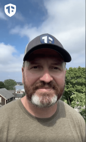 Coach Brandon Jenkins is pictured outside, wearing a Tier One hat.