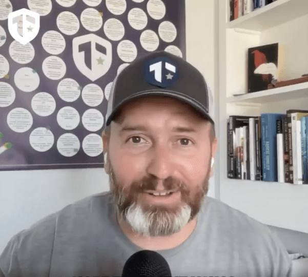 Coach Brandon Jenkins speaks about mindset in leadership. He is pictured in his office, wearing a Tier One hat.