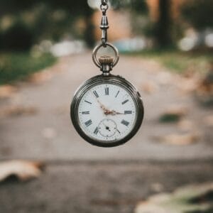 Author and Coach Brandon Jenkins writes about being a leader in current times. Picture shows a pocket watch dangling in front of a sidewalk.