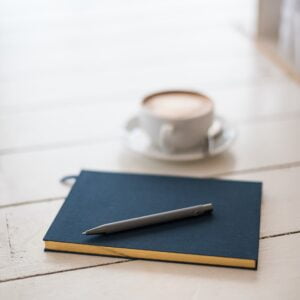 bookblock-11-15cYOiQc-unsplash-2 Journal and coffee on a table, symbolizing reflection.