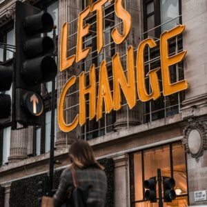 brad-starkey-5qFGBb4yUyk-unsplash Sign reads "Let's Change." Author Brandon Jenkins writes about change and discovering your Blueprint.