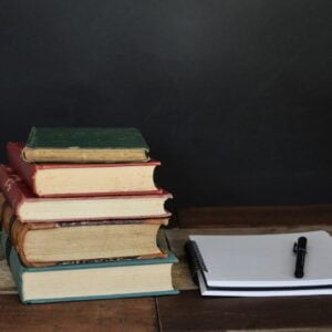 debby-hudson-asviIGR3CPE-unsplash Books with journal and pen on a desk.