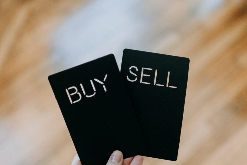 Buy and Sell options held by a hand