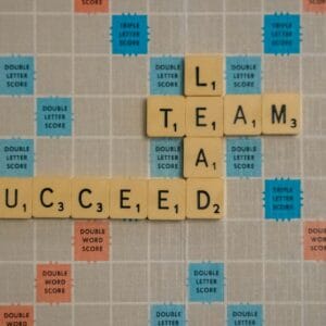 Coach Brandon Jenkins writes about the importance of having a peer coaching group. Image shows a Scrabble board with the words Lead, Team and Succeed.