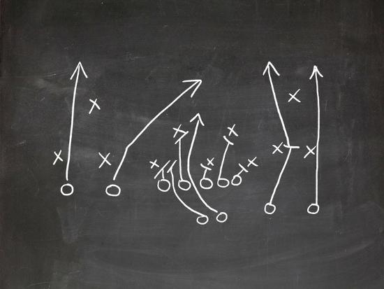 A black and white image of an American Football play. Author, Brandon Jenkins, writes about leading with a coaching mindset. 