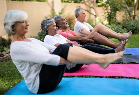 Dedicated senior friends doing stretching exercise Dedicated senior friends doing stretching exercise